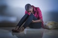 Lifestyle indoors portrait of young sad and depressed black afro American woman sitting at home floor feeling desperate and worrie Royalty Free Stock Photo