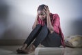 Lifestyle indoors portrait of young sad and depressed black afro American woman sitting at home floor feeling desperate and worrie Royalty Free Stock Photo