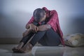 Lifestyle indoors portrait of young sad and depressed black afro American woman sitting at home floor feeling desperate and worrie Royalty Free Stock Photo