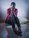 Lifestyle indoors portrait of young sad and depressed black afro American woman sitting at home floor feeling desperate and worrie Royalty Free Stock Photo