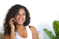 Lifestyle isolated portrait of young happy and gorgeous black african American woman talking on mobile phone at home living room s Royalty Free Stock Photo