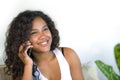 Lifestyle isolated portrait of young happy and gorgeous black afro American woman talking on mobile phone at home living room sofa Royalty Free Stock Photo