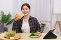 Lifestyle in living room concept, Asian woman drinking orange juice and eating vegetable salad Royalty Free Stock Photo