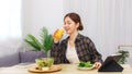 Lifestyle in living room concept, Asian woman drinking orange juice and eating vegetable salad Royalty Free Stock Photo