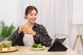 Lifestyle in living room concept, Asian woman watching movie on tablet and drinking orange juice Royalty Free Stock Photo