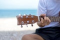 Lifestyle man. Close up handsome man playing classic guitar sitting on the beach in vacations,summer. Royalty Free Stock Photo