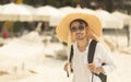 Lifestyle man wears straw hat and sunglasses with white shirt walking on the Sai Keaw beach, Koh Samed, Rayong province, Thailand