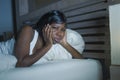 Night portrait of young sad and worried black afro American woman in bed at home sleepless and stressed feeling depressed sufferin Royalty Free Stock Photo