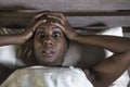 Lifestyle night portrait of young scared and stressed black afro American woman depressed on bed upset unable to sleep suffering h