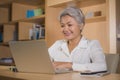 Lifestyle office portrait of attractive and happy successful middle aged Asian woman working at laptop computer desk smiling Royalty Free Stock Photo