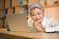 Lifestyle office portrait of attractive and happy successful middle aged Asian woman working at laptop computer desk smiling Royalty Free Stock Photo