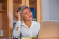 Lifestyle office portrait of attractive and happy successful middle aged Asian woman working at laptop computer desk smiling Royalty Free Stock Photo