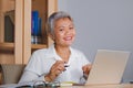 Lifestyle office portrait of attractive and happy successful middle aged Asian woman working at laptop computer desk smiling Royalty Free Stock Photo