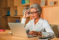 Lifestyle office portrait of attractive and happy successful middle aged Asian woman working at laptop computer desk smiling Royalty Free Stock Photo