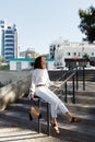 Lifestyle outdoor portrait of beautiful pretty stylish sensual african woman wearing jeans and shirt sitting on stairs Royalty Free Stock Photo