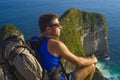 Lifestyle outdoors portrait of young attractive and handsome man with backpack trekking beach cliff looking at beautiful sea Royalty Free Stock Photo