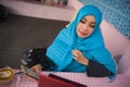 Young beautiful and happy woman in muslim hijab head scarf working with laptop computer and mobile phone networking running inter Royalty Free Stock Photo