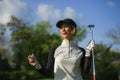 Lifestyle outdoors portrait of young beautiful and happy woman at playing golf holding ball and putter club smiling cheerful in st Royalty Free Stock Photo