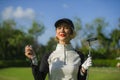 Lifestyle outdoors portrait of young beautiful and happy woman at playing golf holding ball and putter club smiling cheerful in st Royalty Free Stock Photo