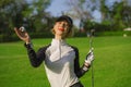 Lifestyle outdoors portrait of young beautiful and happy woman at playing golf holding ball and putter club smiling cheerful in st Royalty Free Stock Photo