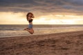 Lifestyle outdoors portrait of young happy and beautiful Asian Korean woman jumping crazy excited on sunset beach having fun caref Royalty Free Stock Photo