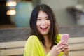 Lifestyle outdoors urban portrait of young attractive and beautiful Asian Japanese woman enjoying using internet social media app Royalty Free Stock Photo