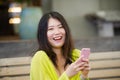 Lifestyle outdoors urban portrait of young attractive and beautiful Asian Japanese woman enjoying using internet social media app Royalty Free Stock Photo