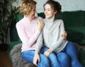 Lifestyle and people concept - Beautiful senior mom and her adult daughter are hugging, looking at camera and smiling. Royalty Free Stock Photo