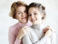 Lifestyle and people concept - Beautiful senior mom and her adult daughter are hugging, looking at camera and smiling, Royalty Free Stock Photo