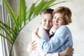 Lifestyle and people concept - Beautiful senior mom and her adult daughter are hugging, looking at camera and smiling. Royalty Free Stock Photo