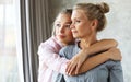 Lifestyle and people concept - beautiful senior mom and her adult daughter are hugging, looking at camera and smiling. Royalty Free Stock Photo