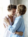 Lifestyle and people concept - Beautiful senior mom and her adult daughter are hugging, looking at camera and smiling. Royalty Free Stock Photo