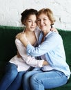 Lifestyle and people concept - Beautiful senior mom and her adult daughter are hugging, looking at camera and smiling. Royalty Free Stock Photo