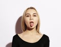 Lifestyle and people concept. Emotional girl. Beautiful modern model shows tongue. Emotions on face. Royalty Free Stock Photo