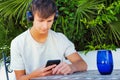 Lifestyle and people concept. Man sitting outdoor and looking at the mobile phone in their hands Royalty Free Stock Photo