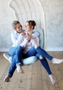 Mature motherand daughter hugging each other in armchair. Royalty Free Stock Photo