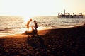 Lifestyle people concept: three little boys silhouette on sunset beach playing in water Royalty Free Stock Photo