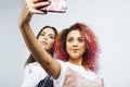 Lifestyle people concept: two pretty stylish modern hipster teen girl having fun together, diverse nation mixed races