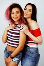 Lifestyle people concept: two pretty stylish modern hipster teen girl having fun together, diverse nation mixed races