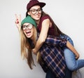 lifestyle and people concept: Two young girl friends standing together and having fun. Looking at camera. Royalty Free Stock Photo