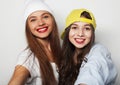 lifestyle and people concept: Two young girl friends standing together and having fun. Looking at camera. Royalty Free Stock Photo