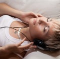 Woman in living room listening to MP3 player smiling Royalty Free Stock Photo