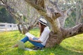 Lifestyle person Girl enjoy listening music and reading a book and play laptop on the grass field