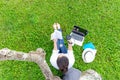 Lifestyle person Girl enjoy reading a book and play laptop on the grass field of the nature park Royalty Free Stock Photo