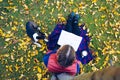 Lifestyle person A young girl is reading a book under a tree wit