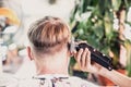 Lifestyle photo barbershop. Young man customer wears face mask, side back rear view. Hairdresser male hand work move Royalty Free Stock Photo