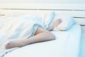 Lifestyle photo of girl under the covers on bed