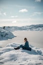 Lifestyle photo of young woman enjoying winter nature in Norway. Covered in blanket she is soaking in sunshine. Royalty Free Stock Photo