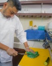 Lifestyle portrait of Asian home cook man or professional chief preparing for cooking and making Japanese sushi rolls wearing Royalty Free Stock Photo