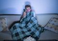 Lifestyle portrait of attractive scared and nervous man watching suspense horror movie on television feeling stressed covering wit